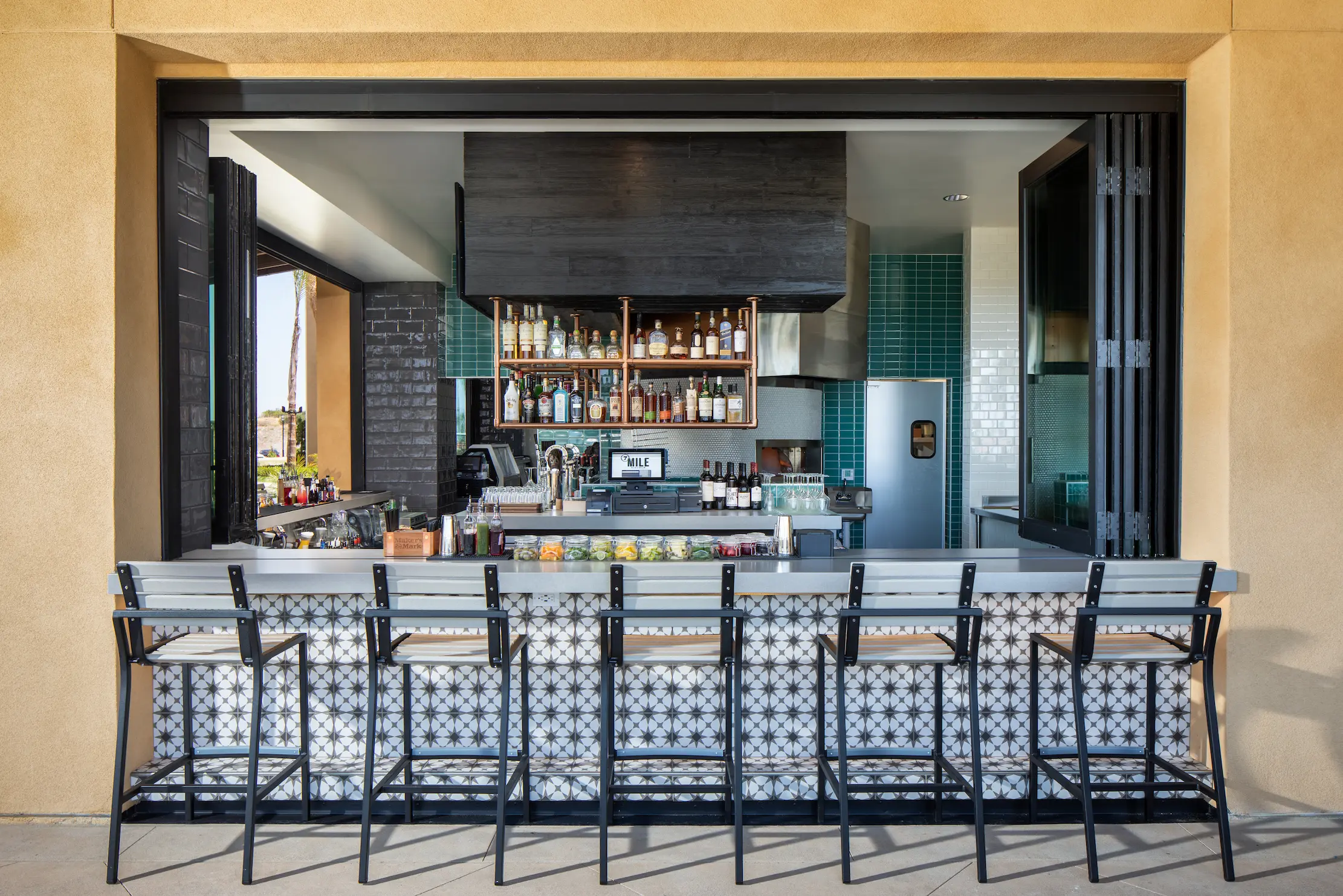 putdoor bar with hig top chairs assorted beverages.