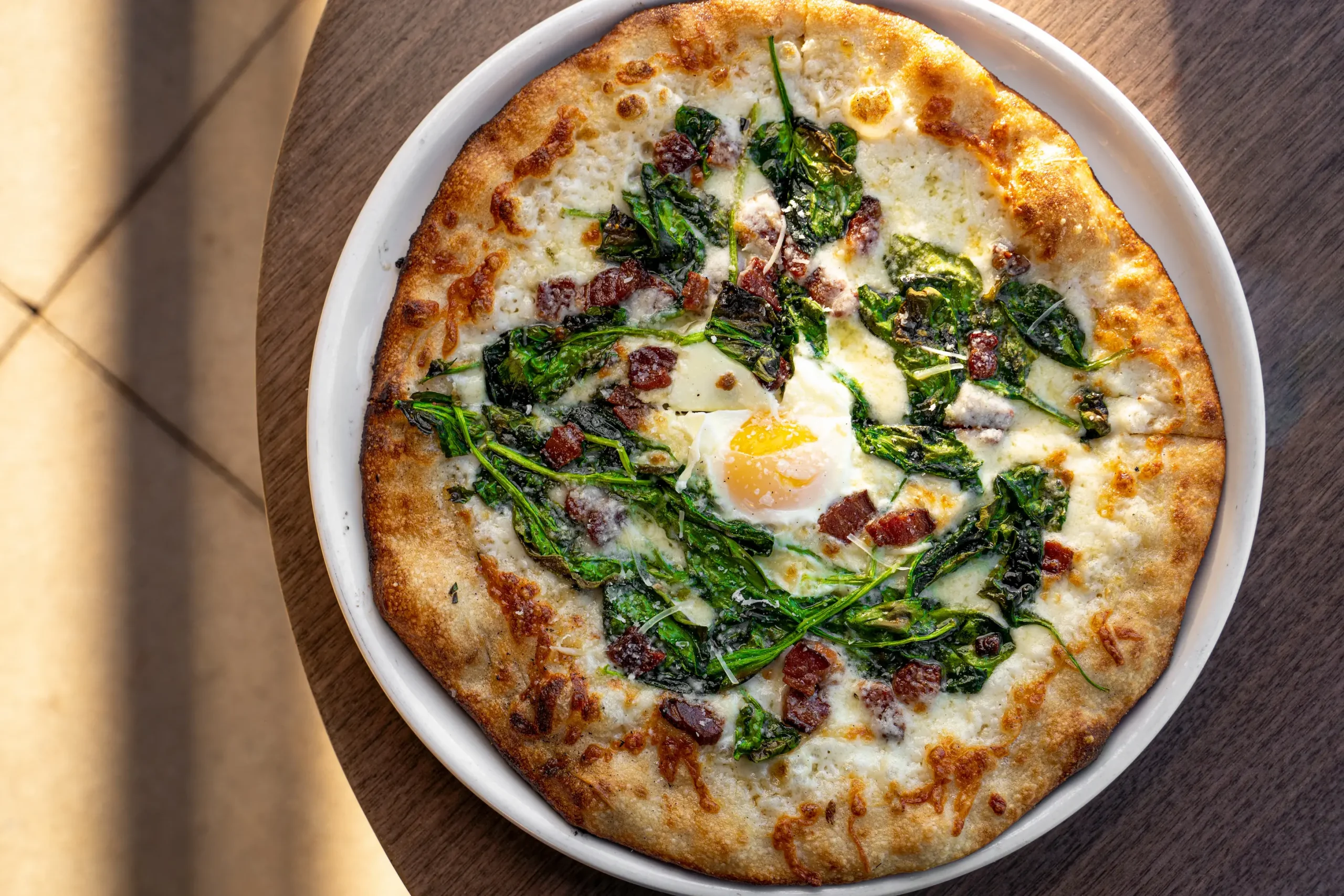 Carbonaro pizza with bacon, white sauce and runny egg