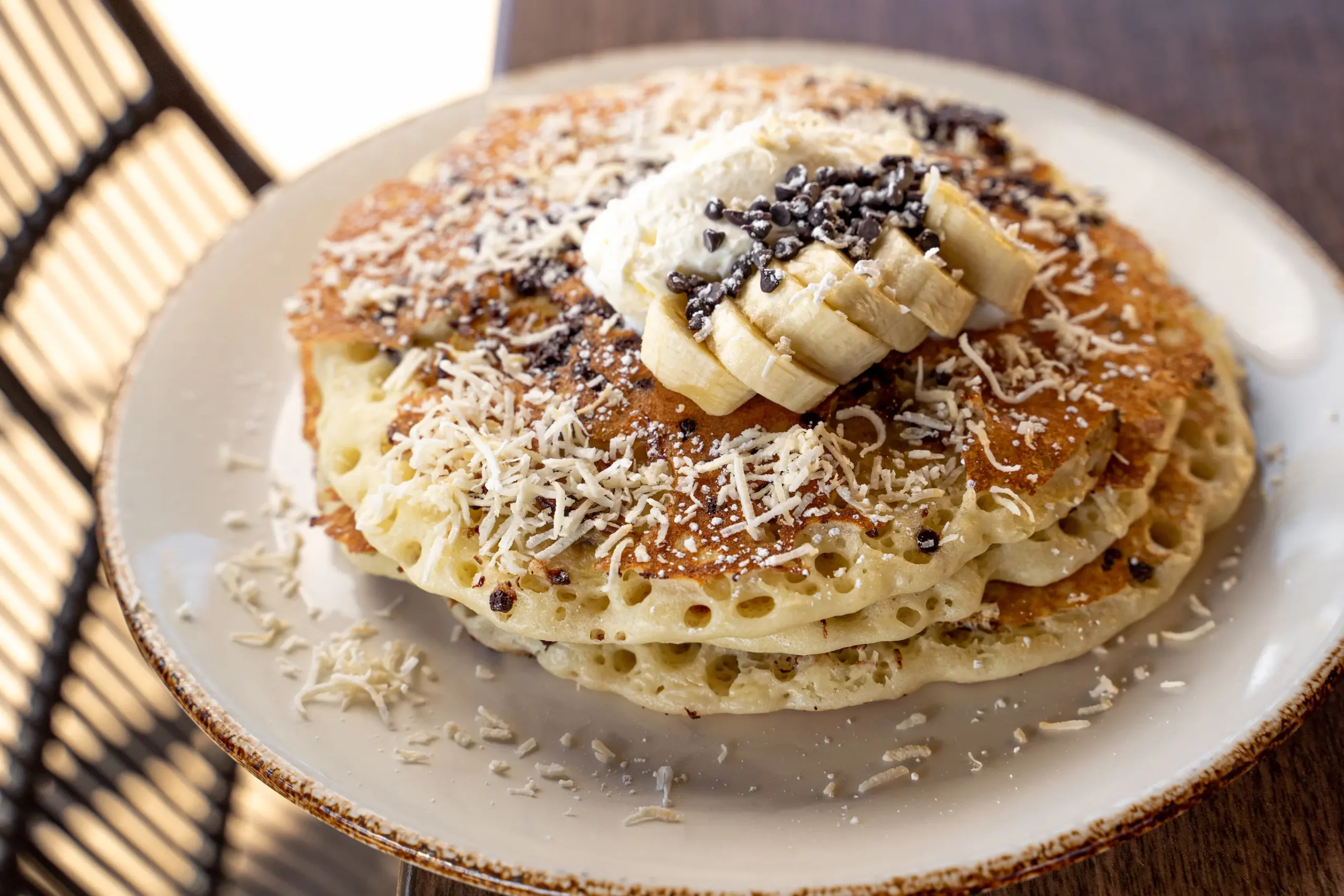 Chocolate chip pancakes with bananas and coconut flakes