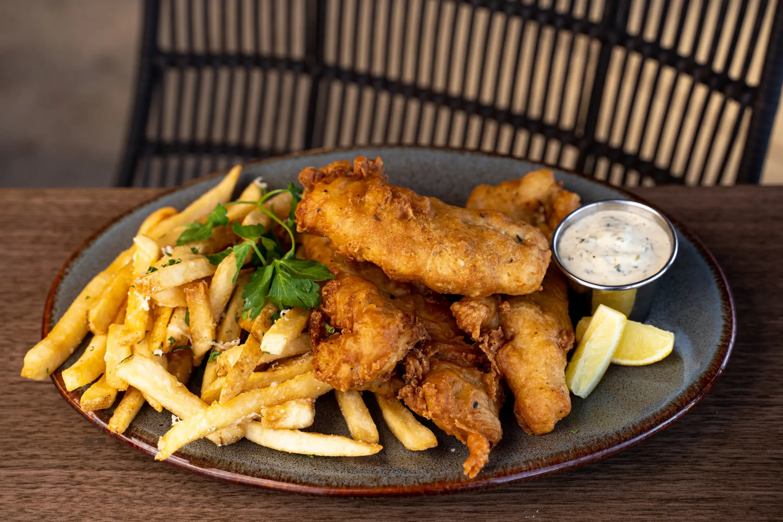 golden fried beer battered fish and french fries plate outdoors